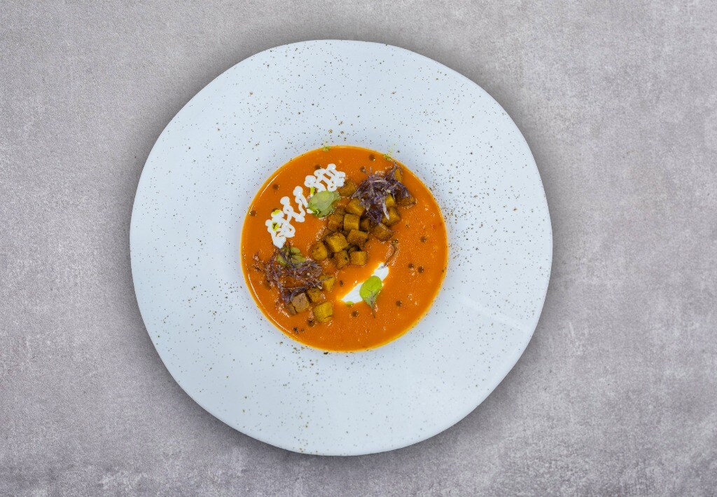 Supă cremă de roșii cu ardei copți servită cu quenelle de brânză de capră și crutoane aromatizate cu busuioc – - Reţetă